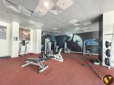 a gym with cardio equipment and a wall with a poster at Vogue Marina Dorra Bay near JBR Beach and Ain Dubai, Two Bedroom apartment with Balcony, Canal and Skyline View, Access to all Amenities in Dubai