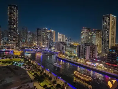 a city skyline at night with a river and buildings at Vogue Marina Dorra Bay near JBR Beach and Ain Dubai, Two Bedroom apartment with Balcony, Canal and Skyline View, Access to all Amenities in Dubai