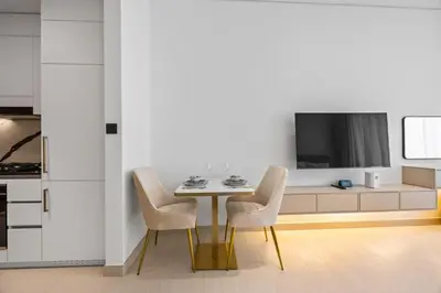 a dining room with a table and chairs and a tv at Luxury Studio with Private Jacuzzi &Canal View in Dubai
