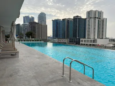 a large swimming pool with a city in the background at Luxury Studio with Private Jacuzzi &Canal View in Dubai