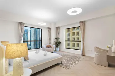 a white living room with a bed and a couch at Cozy 3 Bedroom with walking access to JBR Beach in Dubai