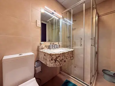 a bathroom with a sink and a shower and a toilet at Mahenti - Spacious 1-Bedroom Apartment in JVC in Dubai