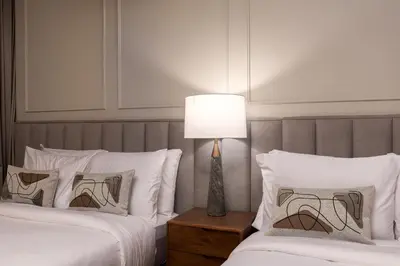 a bedroom with two beds and a lamp on a night stand at Luxury 1st Row Burj Khalifa and Fountain Views, Walk to Dubai Mall in Dubai