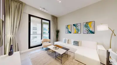 a living room with a white couch and a table at Locations l Upgraded 1 Bedroom l Marina Views l Free Pool Access in Dubai