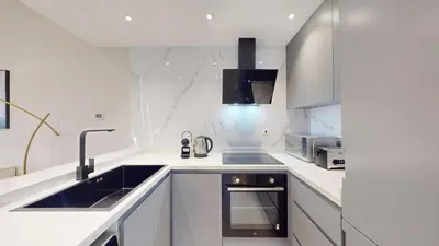 a white kitchen with a sink and a stove at Locations l Upgraded 1 Bedroom l Marina Views l Free Pool Access in Dubai