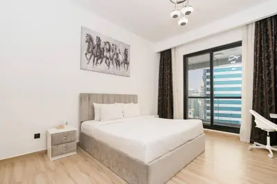 a white bedroom with a bed and a large window at CitiHome - Modern & Stylish 1BR in Dubai Marina in Dubai