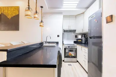 a kitchen with a black counter top and a refrigerator at CitiHome - Modern & Stylish 1BR in Dubai Marina in Dubai