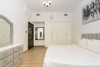 a white bedroom with a large bed and a mirror at CitiHome - Modern & Stylish 1BR in Dubai Marina in Dubai