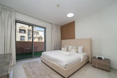 a bedroom with a large bed and a large window at Elegant JVC 1-Bed with Upgraded Interiors in Dubai