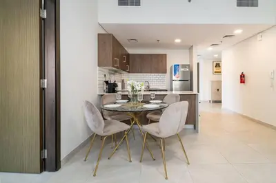 a kitchen and dining room with a table and chairs at Elegant JVC 1-Bed with Upgraded Interiors in Dubai