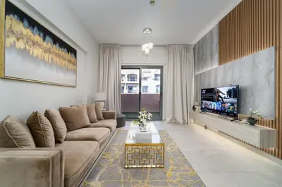 a living room with a couch and a tv at Elegant JVC 1-Bed with Upgraded Interiors in Dubai