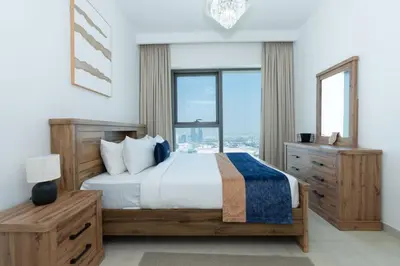 a bedroom with a bed and a large window at CitiHome Luxury 1BR - Downtown Views 2 High Floor in Dubai