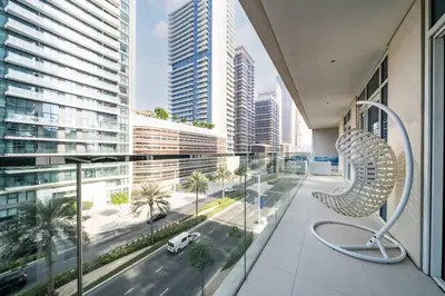 a balcony with a chair and a view of a city at Elegant 2 Bed Beach Front Retreat in Dubai