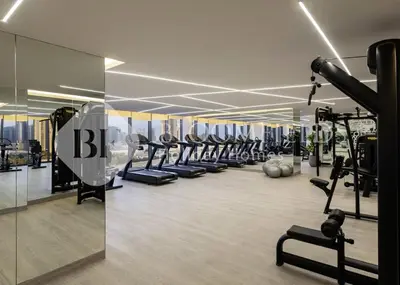 a gym with a lot of treadmills and machines at Bloomfields Magnificent STU Aykon City in Dubai