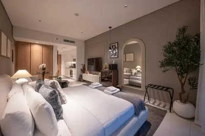 a bedroom with a large white bed in a room at Luxury Studio at Marquise Square with Burj Khalifa View in Dubai