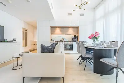 a kitchen and dining room with a table and chairs at Stylish 2BR Stay Near Marina Beach and Ain Dubai, Steps from Shops and Restaurants, Studio One, Dubai Marina by Deluxe Holiday Homes in Dubai