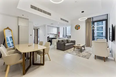 a dining room and living room with a table and chairs at 2 Bed With Balcony Near World Renowned Golf Clubs in Dubai