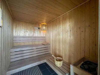 a sauna with a bench and a basket in it at 2 Bed With Balcony Near World Renowned Golf Clubs in Dubai
