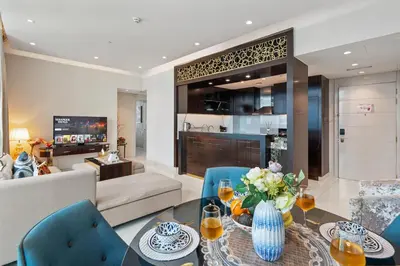 a living room with a couch and a table and chairs at Luxe 2 Bedroom Near Dubai Mall DAMAC Uppercrest Downtown - Free Parking in Dubai