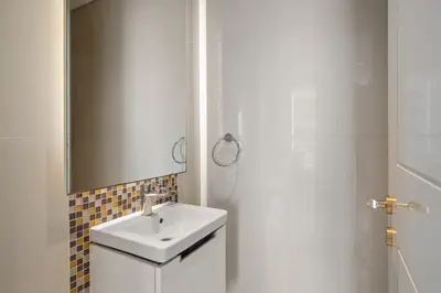 a white bathroom with a sink and a shower at Luxe 2 Bedroom Near Dubai Mall DAMAC Uppercrest Downtown - Free Parking in Dubai