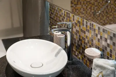 a bathroom with a white sink and aaucet at Luxe 2 Bedroom Near Dubai Mall DAMAC Uppercrest Downtown - Free Parking in Dubai