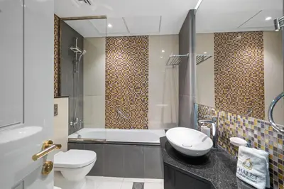 a bathroom with a toilet and a tub and a sink at Luxe 2 Bedroom Near Dubai Mall DAMAC Uppercrest Downtown - Free Parking in Dubai