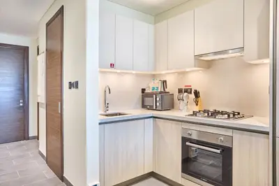 a kitchen with white cabinets and a stove top oven at STAY BY LATINEM Luxury 1BR Plus Holiday Home CB 2408 Near Burj Khalifa in Dubai