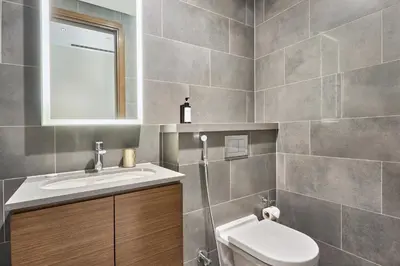 a bathroom with a sink and a toilet and a mirror at STAY BY LATINEM Luxury 1BR Plus Holiday Home CB 2408 Near Burj Khalifa in Dubai