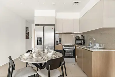 a kitchen with a table and chairs in a kitchen at FIRST CLASS 2BR Burj Khalifa & Pool Views in Dubai