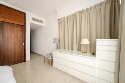 a bedroom with a bed and a dresser with a lamp at Exquisite 2BR Apartment in Dubai Marina in Dubai