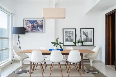 a dining room with a wooden table and white chairs at Exquisite 2BR Apartment in Dubai Marina in Dubai