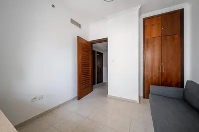 a living room with a couch and a wooden door at Exquisite 2BR Apartment in Dubai Marina in Dubai