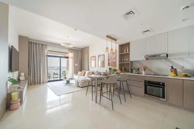 a kitchen and living room with a table and chairs at Frank Porter - Rahaal 2 in Dubai