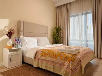 a bedroom with a large bed and a window at 2bed Canalside Home - Marina in Dubai
