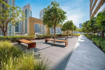 a park with benches and trees and buildings at New LUX 1 BDR apartment in Downtown Dubai in Dubai