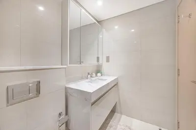a white bathroom with a sink and a mirror at New LUX 1 BDR apartment in Downtown Dubai in Dubai