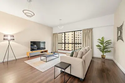 a living room with a couch and a tv at FIRST CLASS 2BR Vibrant Retreat Near JBR Beach in Dubai