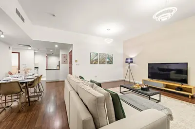 a living room with a couch and a tv and a table at FIRST CLASS 2BR Vibrant Retreat Near JBR Beach in Dubai