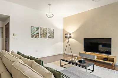 a living room with a couch and a flat screen tv at FIRST CLASS 2BR Vibrant Retreat Near JBR Beach in Dubai