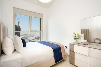 a white bedroom with a bed and a window at CitiHome - Modern Stay - Dubai Hills 2BR in Dubai