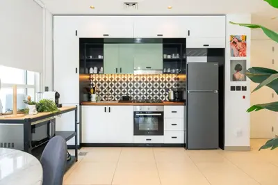 a kitchen with white cabinets and a refrigerator at CitiHome - Modern Stay - Dubai Hills 2BR in Dubai