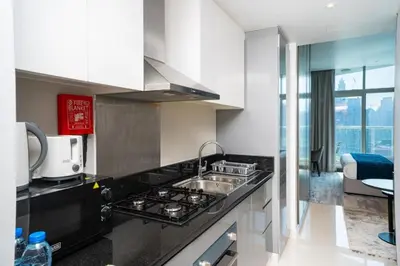 a kitchen with a sink and a stove top oven at Luxury Canal View Studio with Pool Damac Maison Prive in Dubai