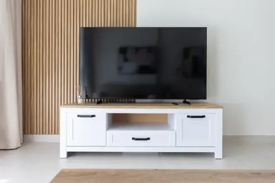 a white entertainment center with a television on top of it at Modern 1BR Apartment with City View in Dubai