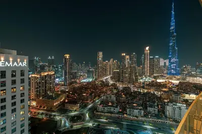 a night view of a city with a tall building at Maison Distinction Suites by Hostiva - Burj and Fountain View in Dubai
