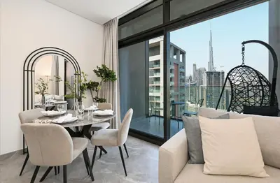 a living room with a couch and a table with chairs at Spacious & Cozy 2BD Apartment Peninsula One, Dubai in Dubai