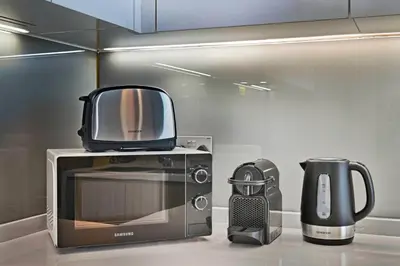 a microwave and a coffee maker and a toaster at Spacious & Cozy 2BD Apartment Peninsula One, Dubai in Dubai