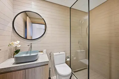 a bathroom with a toilet and a sink and a mirror at Spacious & Cozy 2BD Apartment Peninsula One, Dubai in Dubai