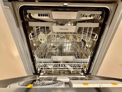 a dishwasher with its door open with dishes in it at 3BR Luxury Stay with Maid Room and Views of Ain Dubai & Sea in Dubai