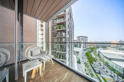 a balcony with chairs and a view of a city at 3BR Luxury Stay with Maid Room and Views of Ain Dubai & Sea in Dubai