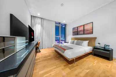 a bedroom with a bed and a flat screen tv at 3BR Luxury Stay with Maid Room and Views of Ain Dubai & Sea in Dubai